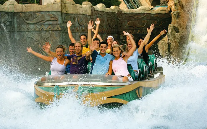 Families enjoying Gardaland Park under colourful lights